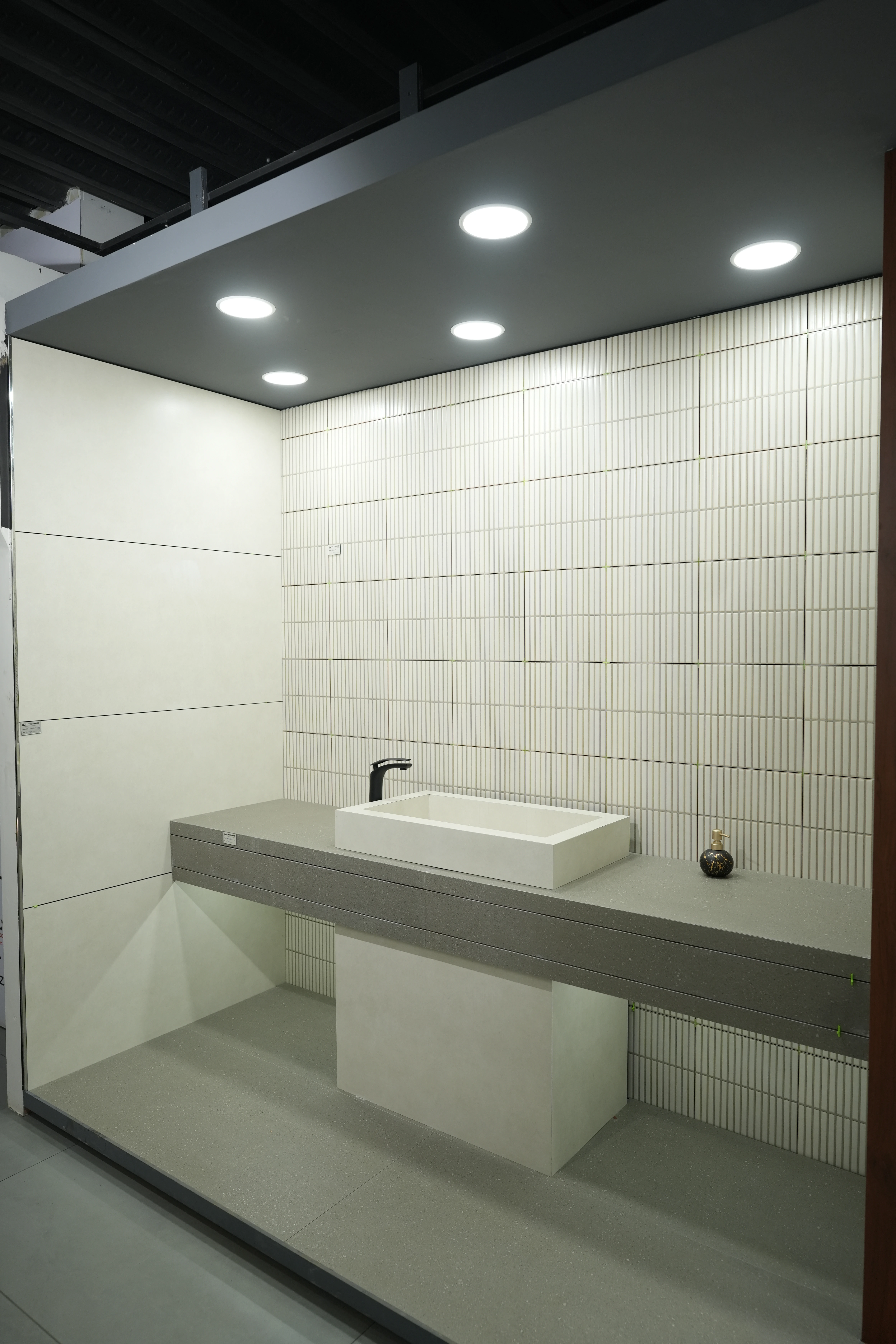 City Ceramics showroom featuring Creanza tiles with a modern minimalist bathroom design, including a sleek square sink and textured wall tiles.