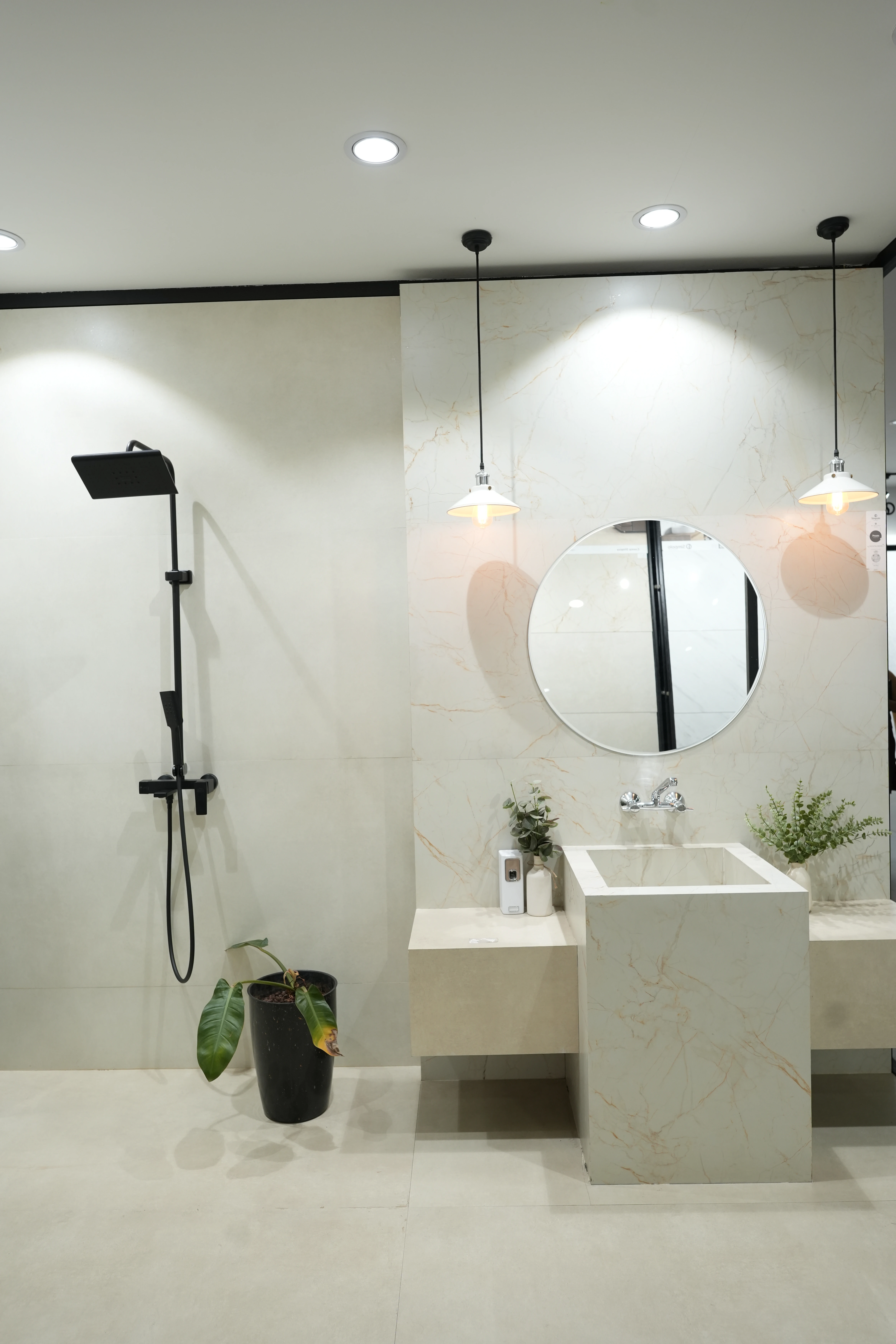 City Ceramics showroom showcasing Simpolo tiles with a modern bathroom setup, featuring a sleek shower, minimalist sink, and stylish pendant lighting.