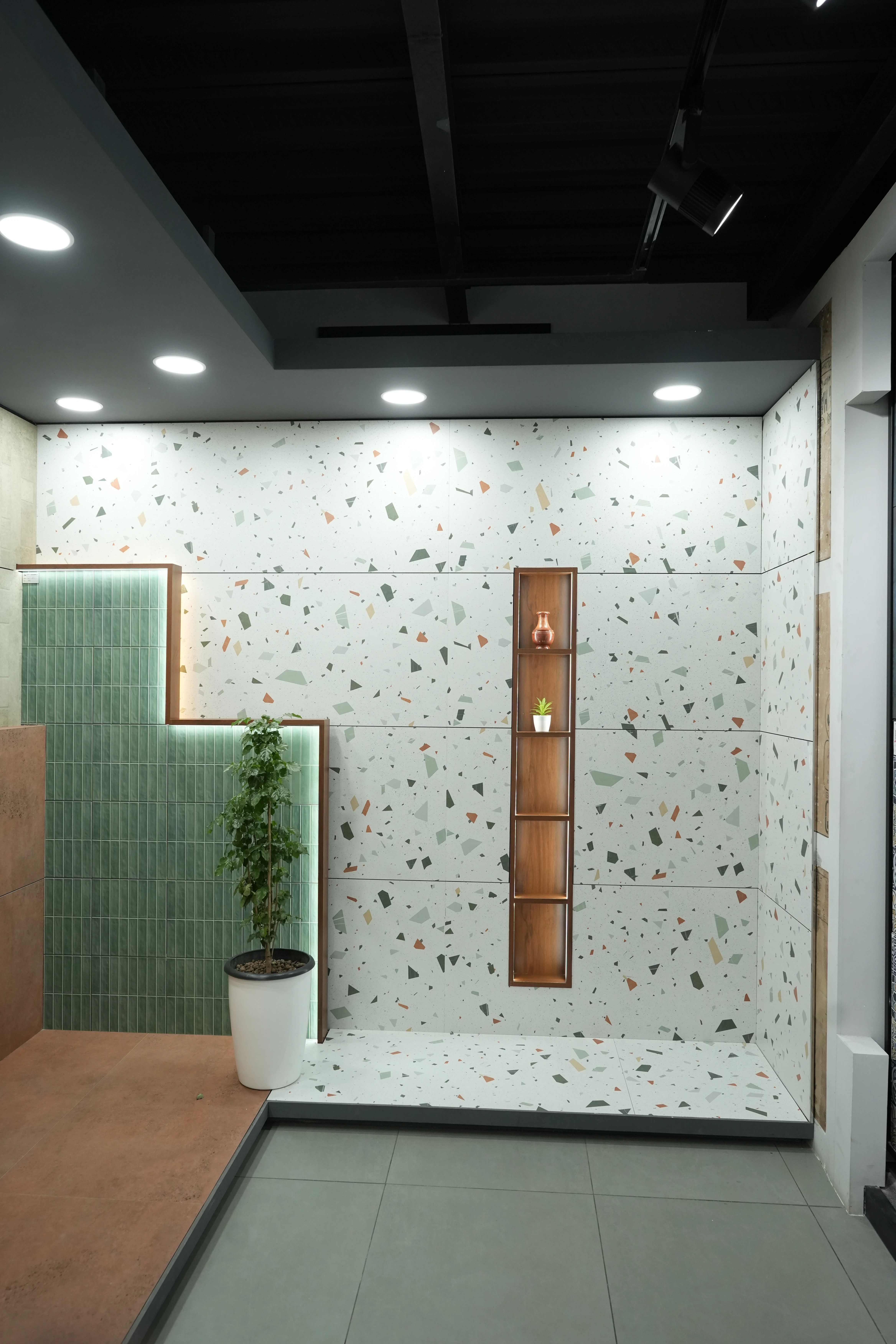 City Ceramics showroom showcasing Creanza tiles with a stylish terrazzo wall design, featuring a modern shelf unit and greenery.